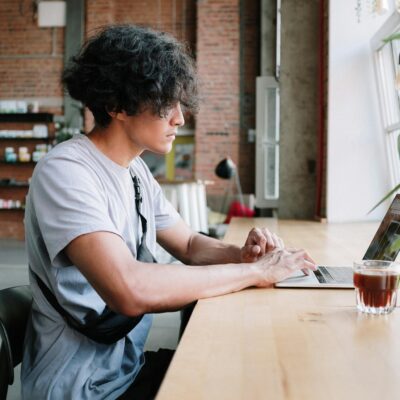 Man in Gray Crew Neck T-shirt Sitting at the Table